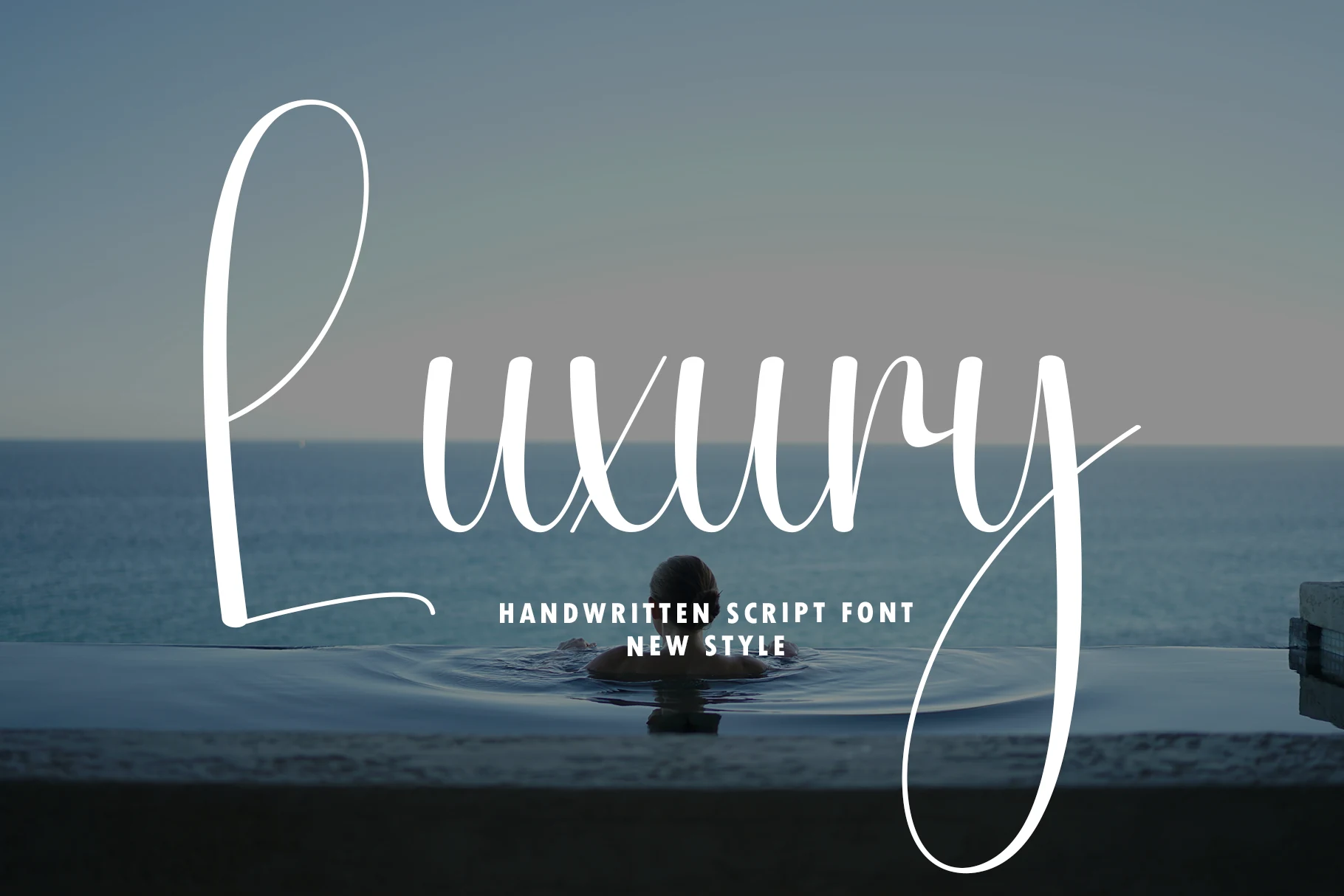 Luxury Font preview in white fluid script with a tall looped L and long sweeping tail