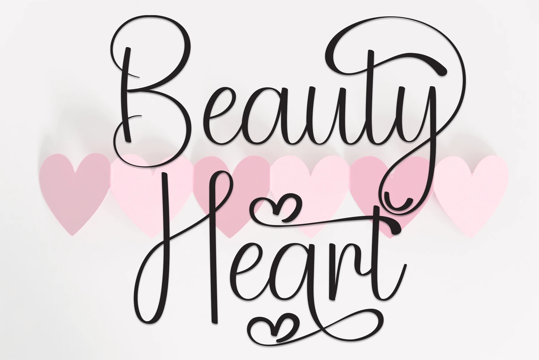 Beauty Heart Font features connected calligraphic lettering with high stroke contrast, elegant swashes, and heart-shaped flourishes.